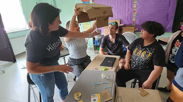 Instructor demonstrating cardboard engineering project